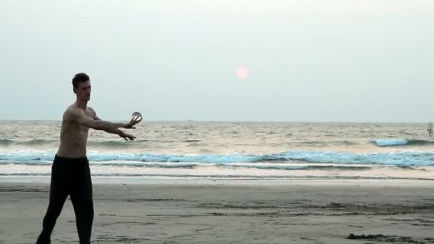 Uomo non identificato giocoleria con palla di vetro sulla spiaggia — Video Stock