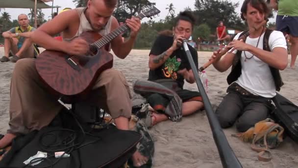 Homem não identificado tocando música na praia . — Vídeo de Stock