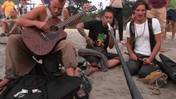 身份不明的男子在海滩上玩音乐. — 图库视频影像