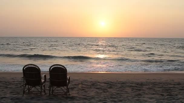 日落的时候在海岸线附近的两把椅子 — 图库视频影像