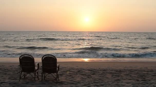 Duas cadeiras perto da costa ao pôr-do-sol — Vídeo de Stock