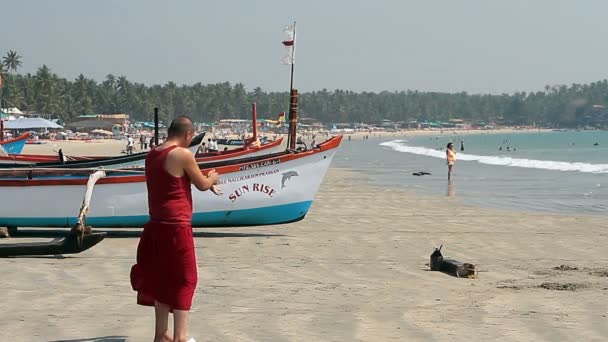 Krishna munk avkopplande på stranden Palolem. — Stockvideo