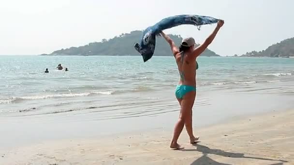 Счастливая молодая женщина, гуляющая по пляжу Палолем — стоковое видео