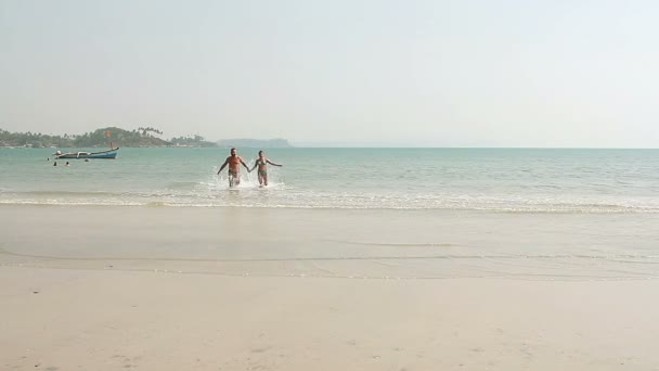 Feliz hombre y mujer nadando en la playa — Vídeos de Stock