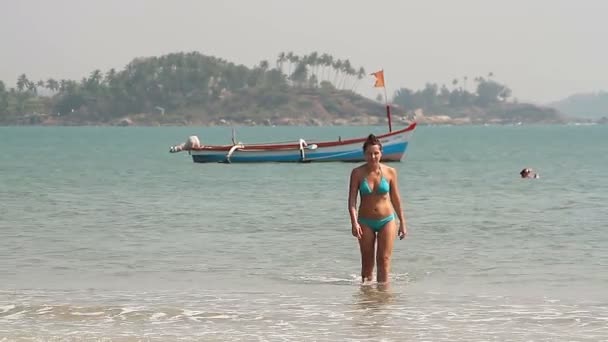 Щаслива молода жінка плаває на пляжі — стокове відео