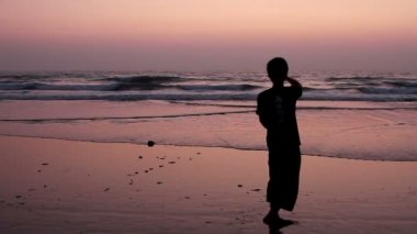 Kimliği belirsiz adam sahilde cam top ile hokkabazlık