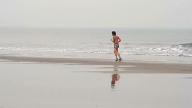Kimliği belirsiz adam sahilde çalıştıran. 