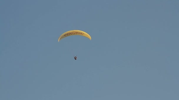 Yamaç paraşütü karşı dağlar üzerine açık mavi gökyüzü — Stok video