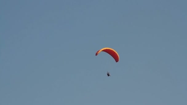 Gleitschirmfliegen über den Bergen vor strahlend blauem Himmel — Stockvideo