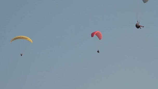 Parapente sobre as montanhas contra o céu azul claro — Vídeo de Stock