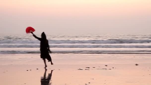 Oidentifierad kvinna dansar med fläkt på stranden. — Stockvideo