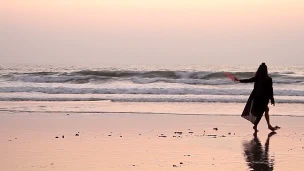 Unbekannte Frau tanzt mit Fächer am Strand. — Stockvideo