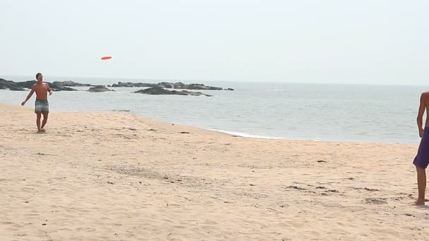 Unidentified man playing Frisbee on the beach — Stock Video