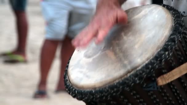 Oidentifierad man spelar på trumman på Arambol beach. — Stockvideo