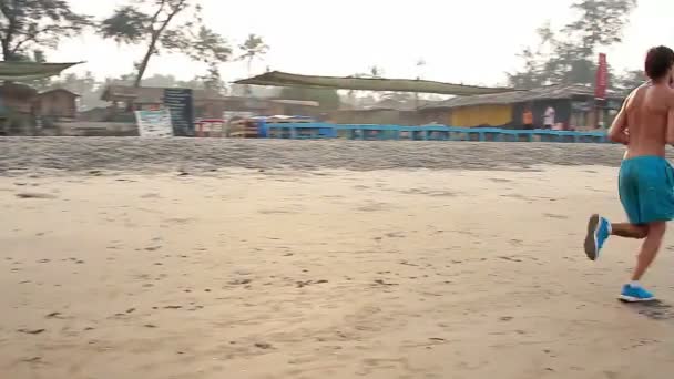 Niezidentyfikowany mężczyzna uruchomiona na plaży. — Wideo stockowe