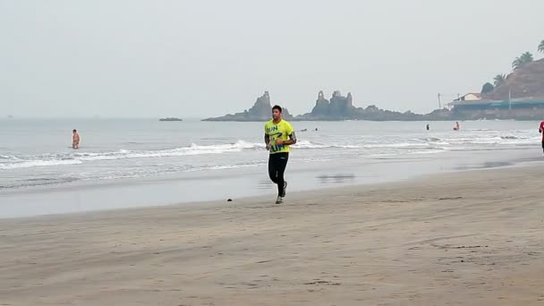 Niezidentyfikowany mężczyzna uruchomiona na plaży. — Wideo stockowe