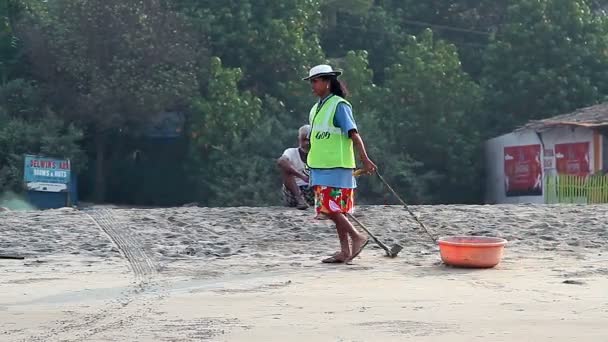 Hombre y mujer no identificados limpiando playa de arena — Vídeos de Stock