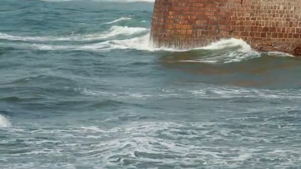 Волны бьют по каменной стене — стоковое видео