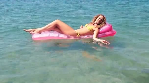 Young girl floating on a mattress in the sea — Stock Video