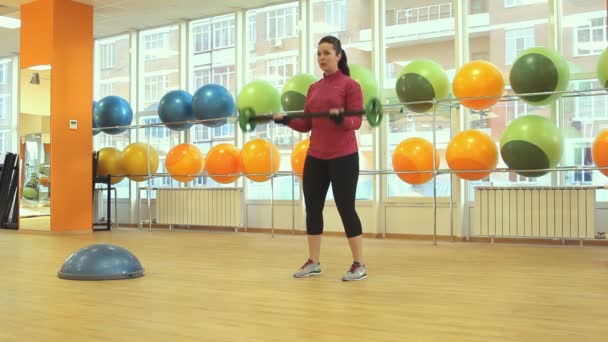 Genç bir kadın ile Halter egzersiz yaparak — Stok video