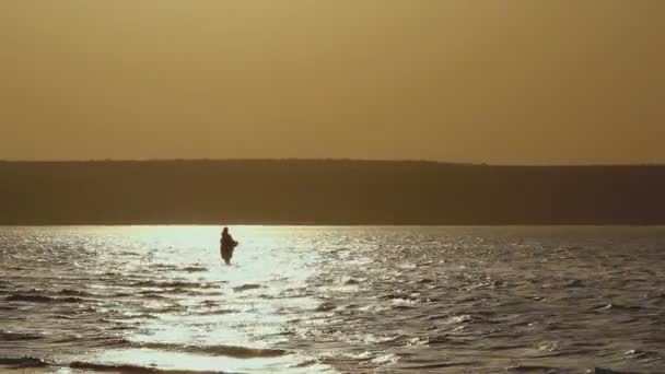 Man fishing in lake at sunset — Stock Video