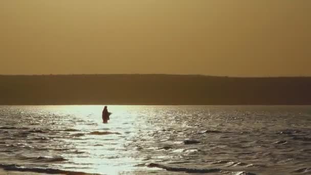 Man fishing in lake at sunset — Stock Video