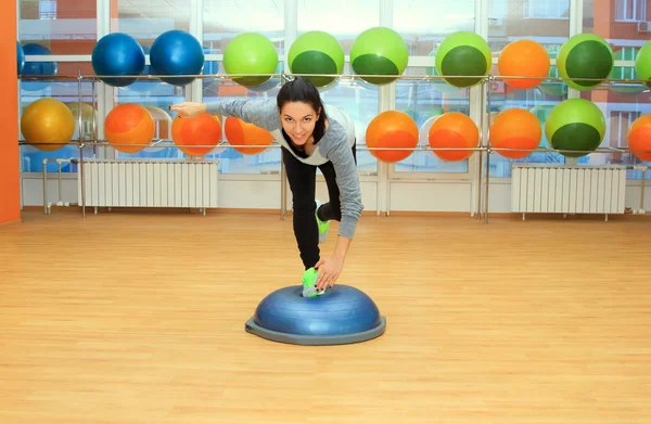 Ung kvinna som motionerar på bosu boll — Stockfoto