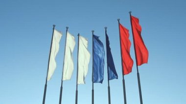 Rüzgarla çırpınan altı kırmızı, mavi ve beyaz bayrak