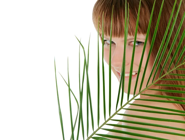 Pretty female behind palm leaf over white — Stock Photo, Image