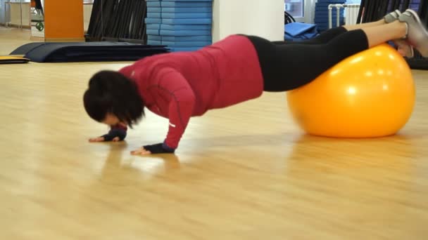 Jovem mulher fazendo exercício de fitness com bola de ajuste — Vídeo de Stock