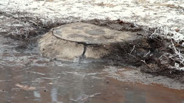 Кришка каналізаційного в аварії на вулиці, вода тече по дорозі з каналізацію — стокове відео