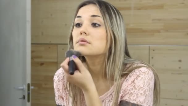 Mooi meisje kijken in de spiegel en het aanbrengen van cosmetische met een grote borstel — Stockvideo