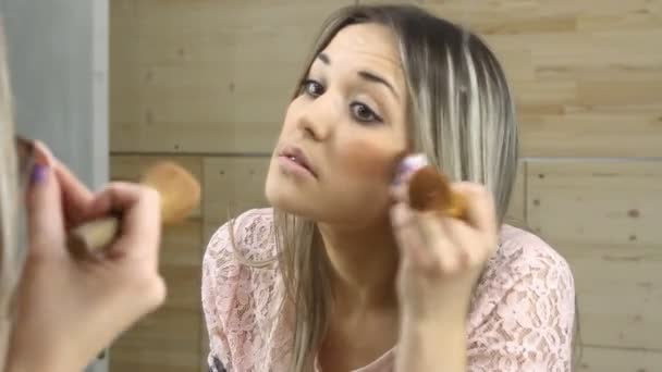 Gadis cantik melihat di cermin dan menerapkan kosmetik dengan sikat besar — Stok Video