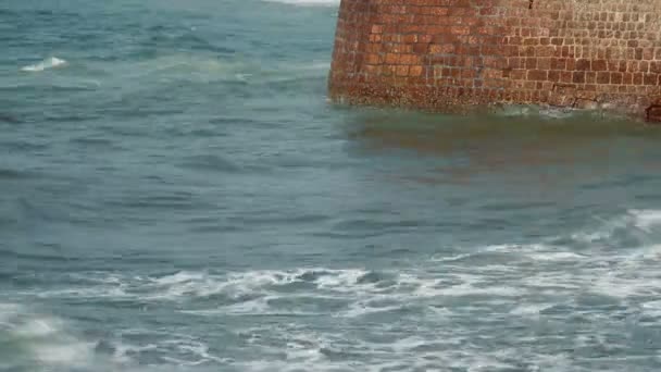 Волны бьют по каменной стене — стоковое видео