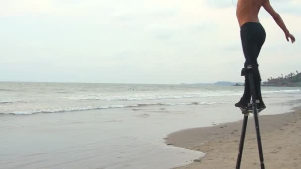 Goa, India - 28 de febrero de 2015: Hombre no identificado bailando sobre los zancos. Goa estado Arambol playa . — Vídeos de Stock