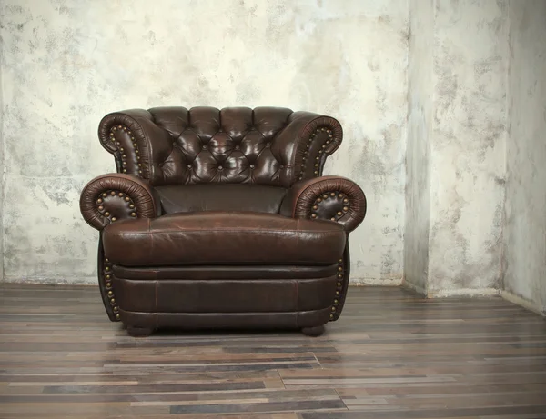 Старий старовинний коричневий шкіряний стілець у порожній кімнаті — стокове фото