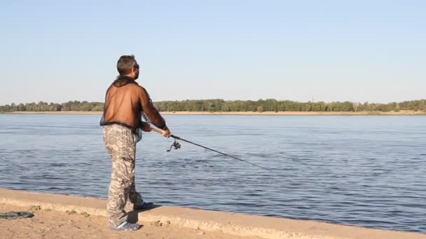 Человек рыбачит на реке — стоковое видео