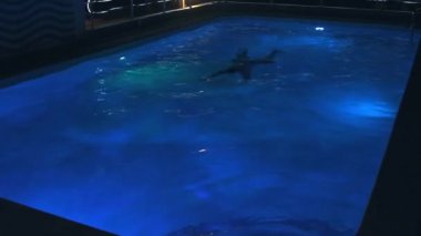 Gece yüzme havuzunda Genç adam