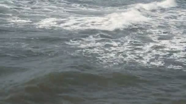 Волны касаются песчаного пляжа в солнечный день — стоковое видео