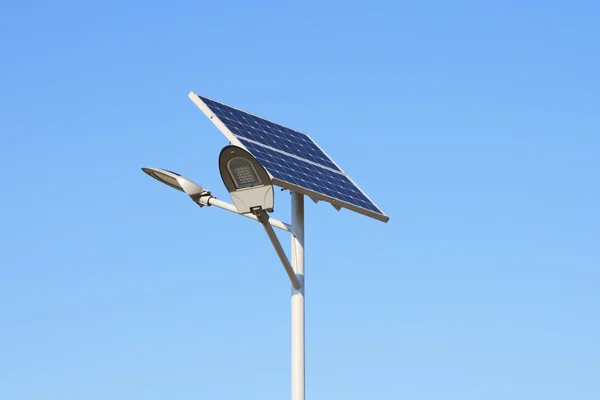 Painéis solares com lâmpada led sobre o céu azul — Fotografia de Stock