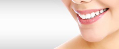 Gri bir arka plan boşaltmak ile gülümseyen güzel kadın