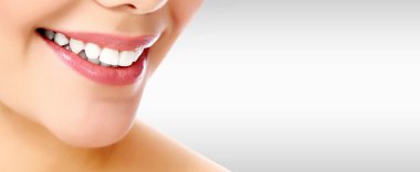 Gri bir arka plan boşaltmak ile gülümseyen güzel kadın