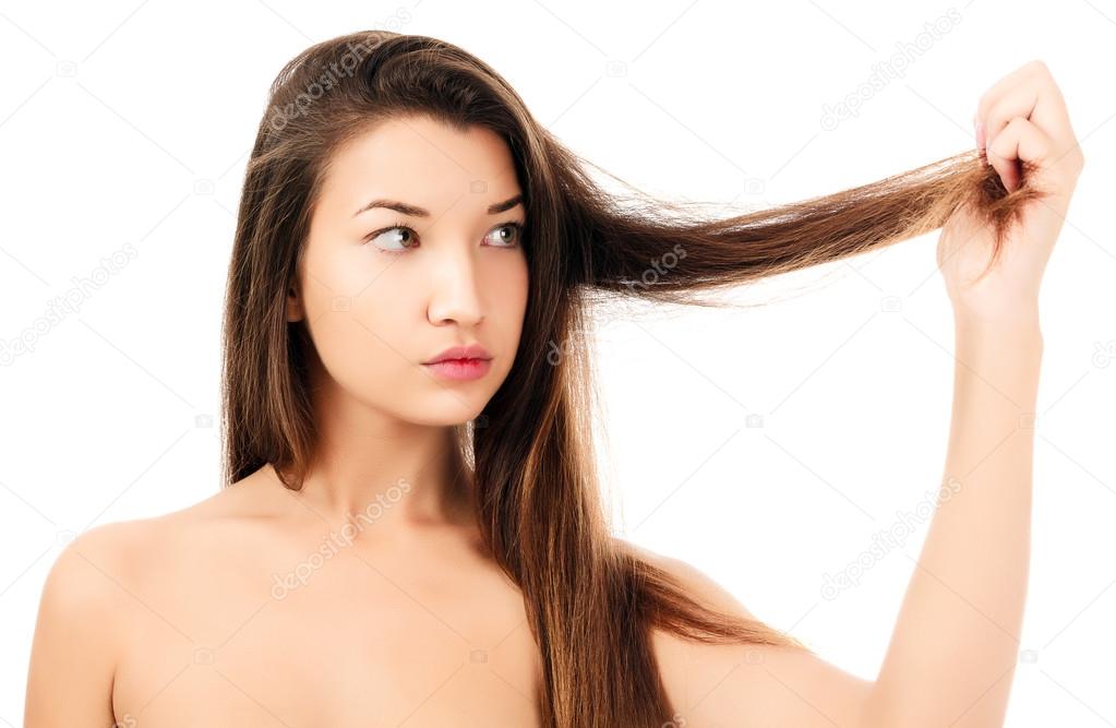 woman looking on her fragile hair, white background, copyspace