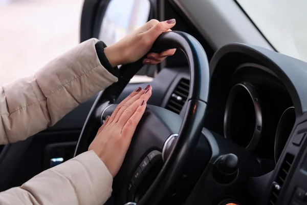 Woman presses on horn button — Stock Photo, Image