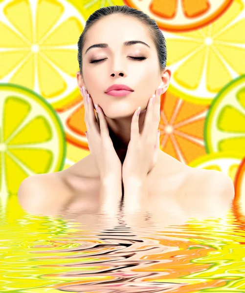 Mujer guapa sobre fondo con rodajas de naranja —  Fotos de Stock