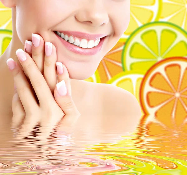 Mujer sonriente sobre un fondo con las rebanadas de naranja —  Fotos de Stock