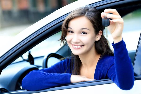 Симпатичная девушка показывает ключ от машины — стоковое фото