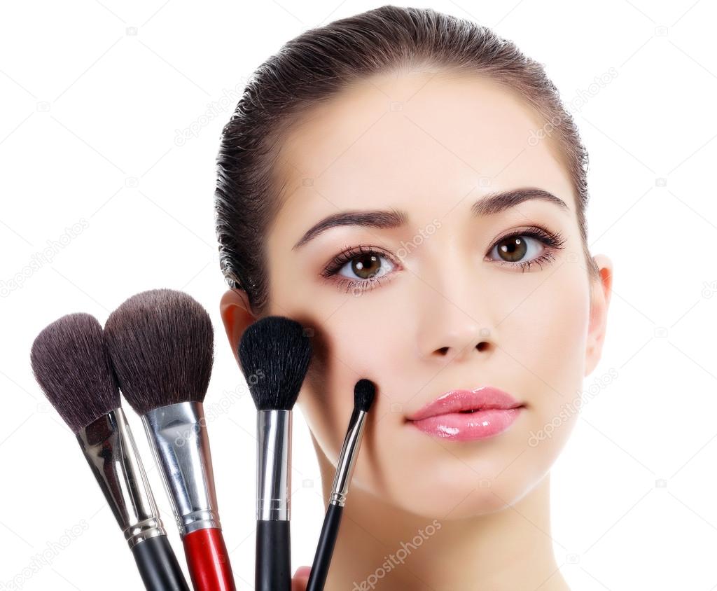 Pretty woman with a makeup brushes, isolated on white