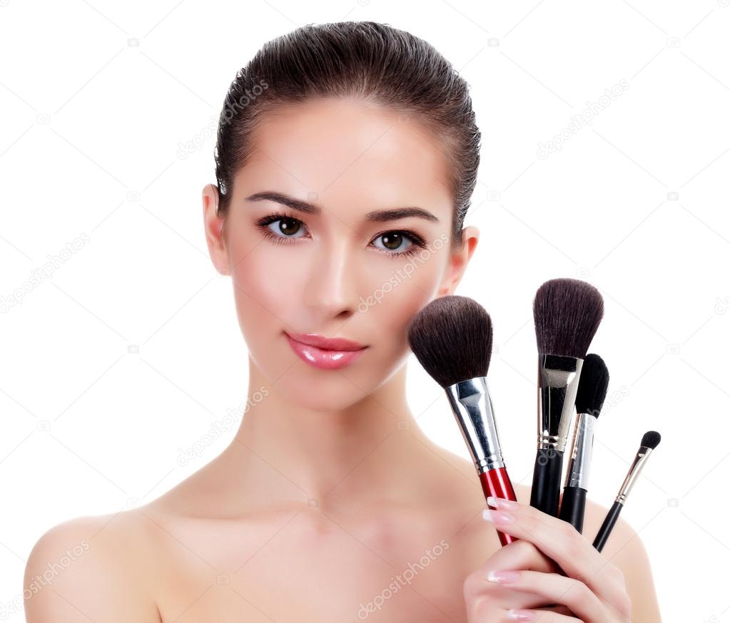 Pretty woman with makeup brushes