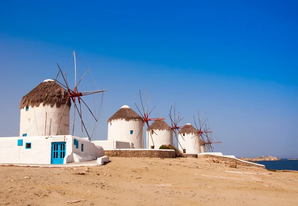 Moinhos de vento em uma colina perto do mar na ilha de Mykonos — Fotografia de Stock